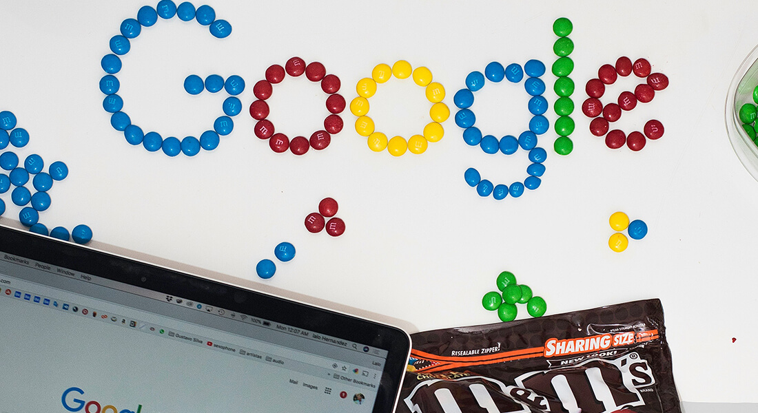 A Chromebook and the word 'Google' written in M&M's. A Chromebook and the word 'Google' written in M&M's.
