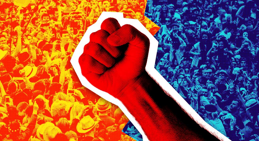 A crowd split in two - a group of people in red collides with a group of people in blue.